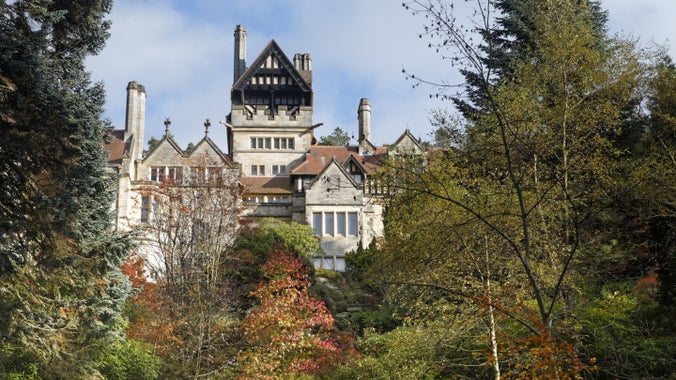A gothic looking house surrounded by autumn trees